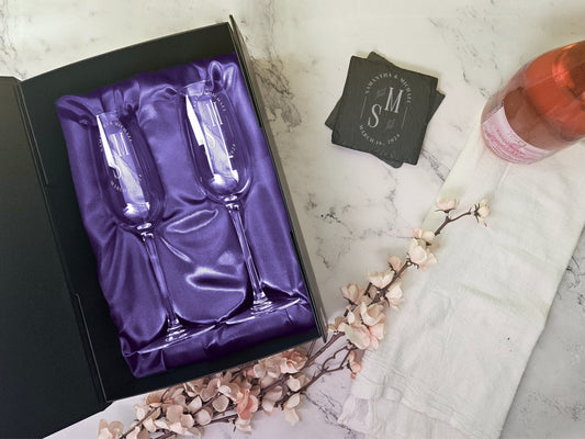 a box of silverware next to a glass of wine