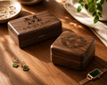 Wooden jewelry boxes with engraved names on a wooden surface