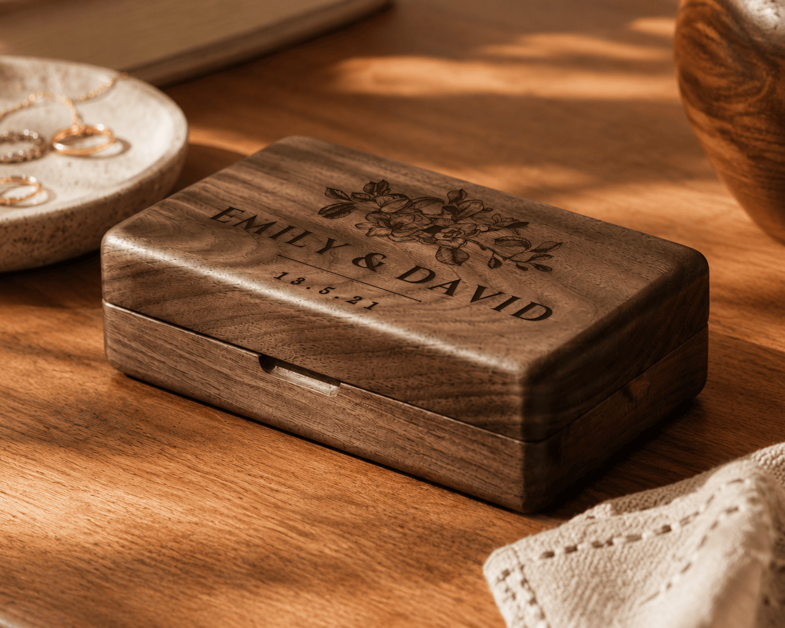 Wooden jewelry box with engraved names and date on a wooden surface