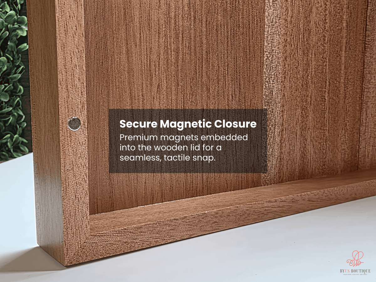 Close-up of a wooden cabinet or shelf corner with a dark brown text label reading 'Secure Magnetic Closure' and a small metal magnet visible in the corner. A white surface and greenery are visible in the background.