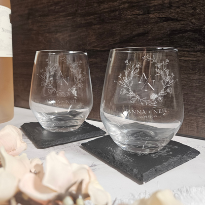 two wine glasses sitting on a table next to a bottle of wine