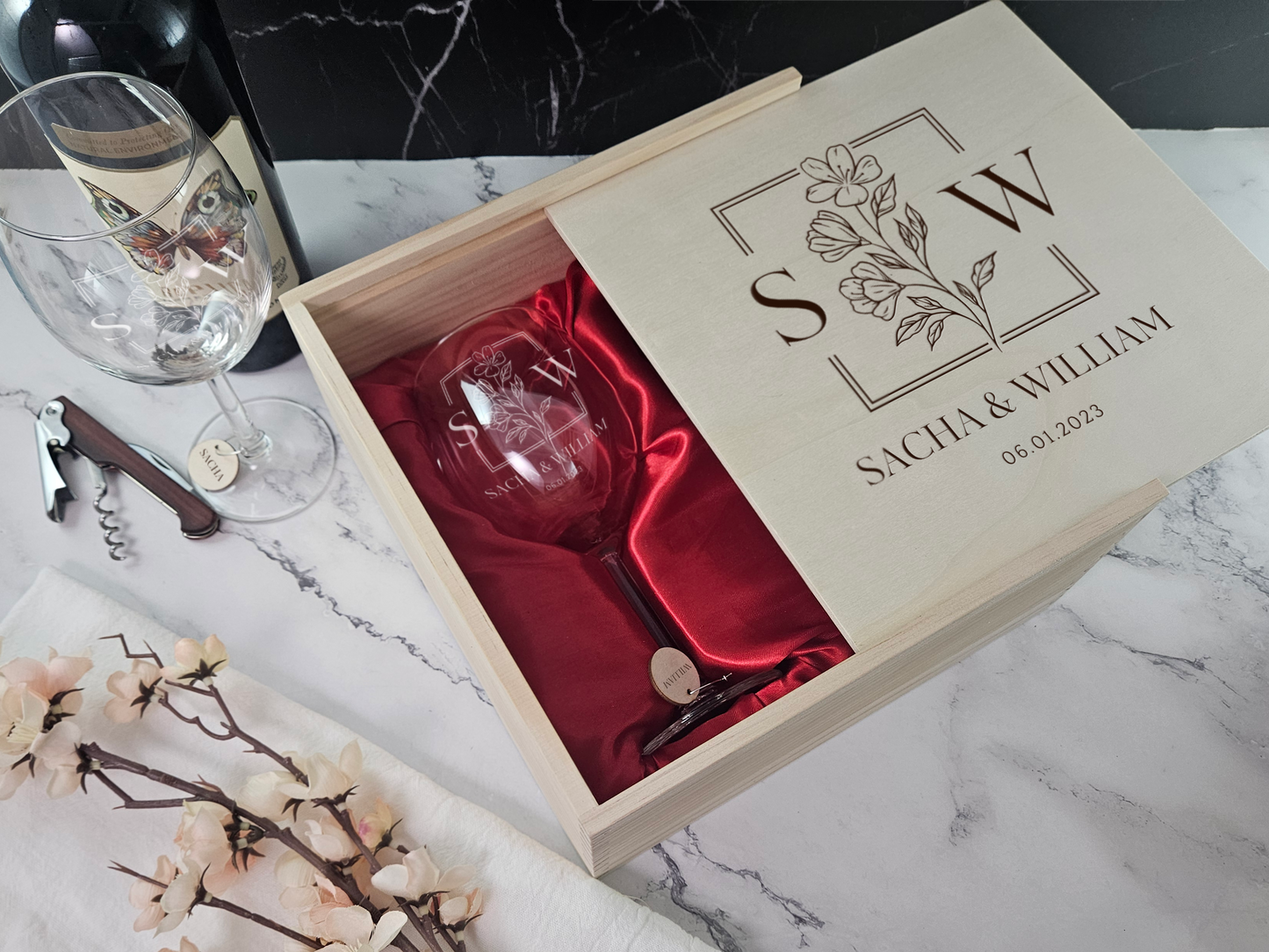 a wine glass in a box next to a bottle of wine