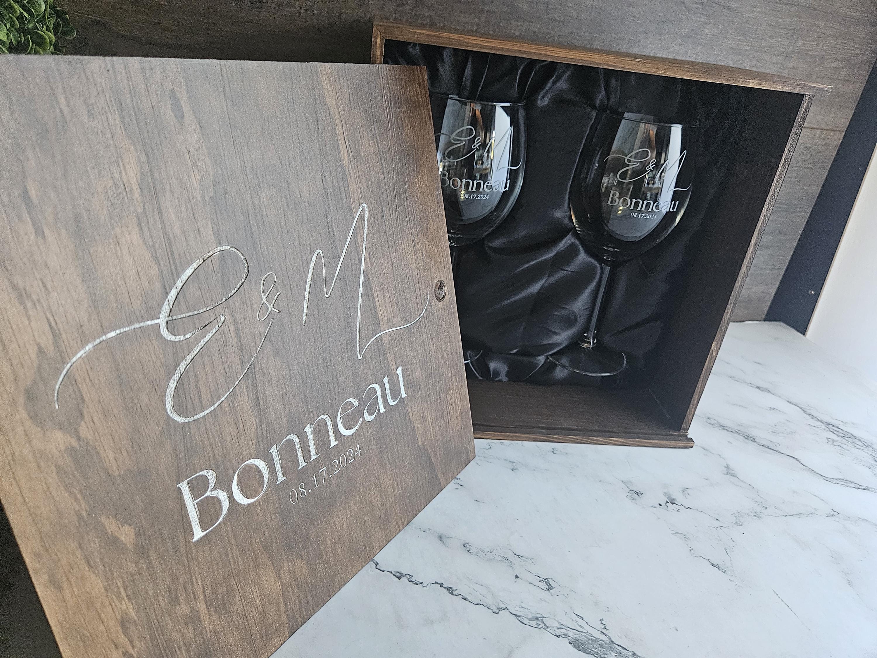 a wooden box with two wine glasses inside of it