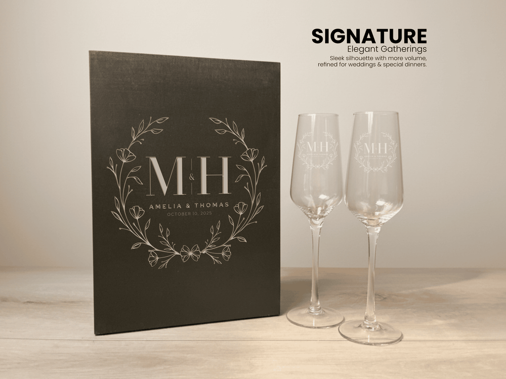 Black wooden box with a custom monogram and two Signature champagne glasses on a wooden surface.